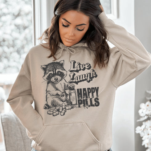 Introducing the "Live, Laugh, Happy Pills" Hoodie—because who better to take life advice from than a raccoon with a bottle of questionable pharmaceuticals? 🦝💊