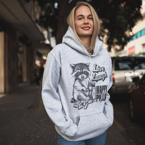 Introducing the "Live, Laugh, Happy Pills" Hoodie—because who better to take life advice from than a raccoon with a bottle of questionable pharmaceuticals? 🦝💊
