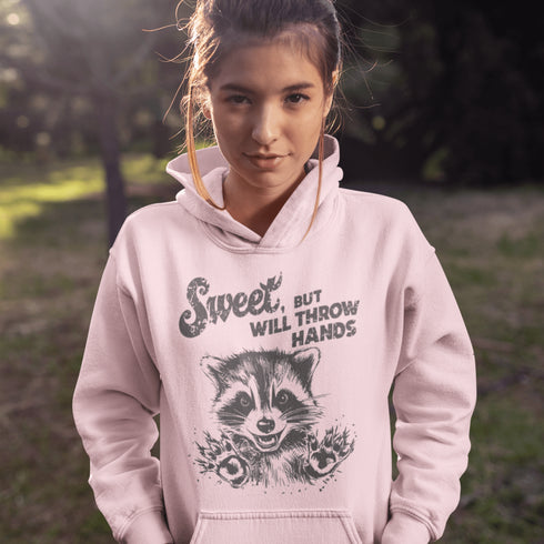 Introducing the "Sweet, But Will Throw Hands" Hoodie—perfect for those who are 90% cute and 10% ready to fight (especially over snacks). Featuring a cartoon raccoon that’s equal parts charming and feisty, this hoodie is a gentle reminder that while you're sweet, you’re not to be messed with! 🦝👊