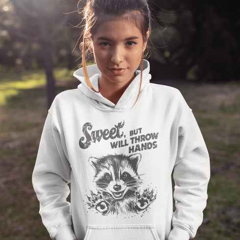 Introducing the "Sweet, But Will Throw Hands" Hoodie—perfect for those who are 90% cute and 10% ready to fight (especially over snacks). Featuring a cartoon raccoon that’s equal parts charming and feisty, this hoodie is a gentle reminder that while you're sweet, you’re not to be messed with! 🦝👊