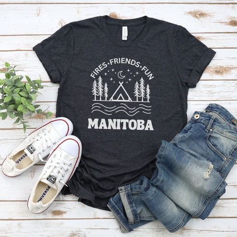 Introducing our exclusive camping t-shirt featuring a camping scene and the catchy slogan "Manitoba - Fires, Friends, Fun."