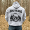 Our Respect the Locals Hoodie features the ultimate forest hangout: Bigfoot and an alien, just two mysterious dudes chilling on logs around a crackling campfire.