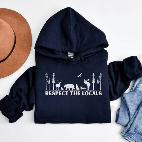 Step into the heart of the forest with our “Respect The Locals” hoodie, where artfully illustrated woodland animals roam under a canopy of trees.