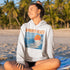 Capture the laid-back charm of lake life with our Winnipeg Beach hoodie. Featuring a vibrant graphic of the town’s iconic water tower set against a beach sunset