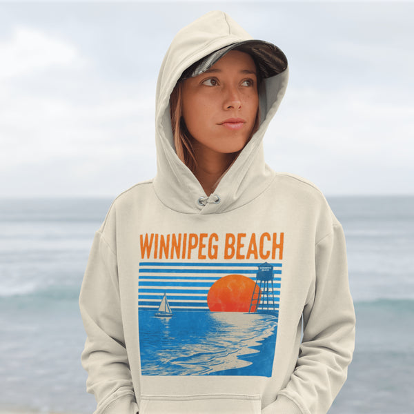 Capture the laid-back charm of lake life with our Winnipeg Beach hoodie. Featuring a vibrant graphic of the town’s iconic water tower set against a beach sunset