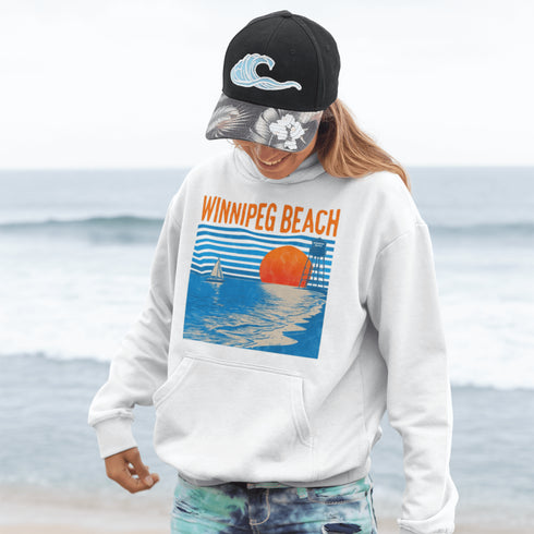 Capture the laid-back charm of lake life with our Winnipeg Beach hoodie. Featuring a vibrant graphic of the town’s iconic water tower set against a beach sunset