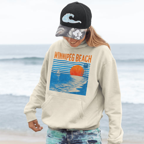 Capture the laid-back charm of lake life with our Winnipeg Beach hoodie. Featuring a vibrant graphic of the town’s iconic water tower set against a beach sunset