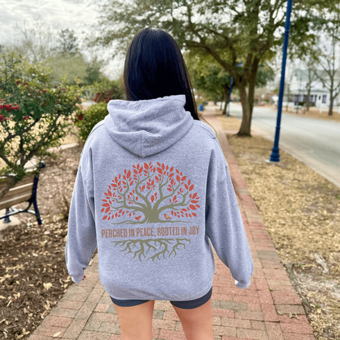 This design features a beautifully crafted tree with flowing roots, symbolizing strength and connection, paired with the uplifting saying, "Perched in peace, rooted in joy."