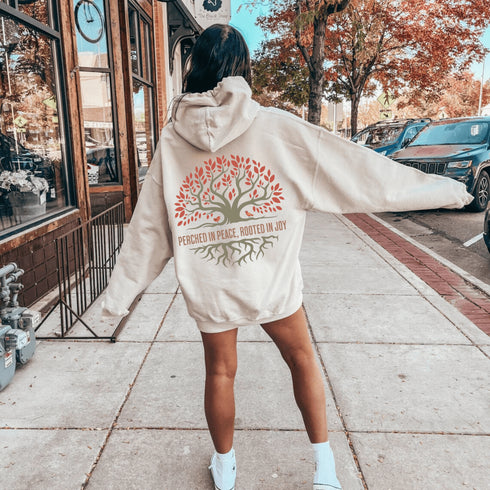 This design features a beautifully crafted tree with flowing roots, symbolizing strength and connection, paired with the uplifting saying, "Perched in peace, rooted in joy."