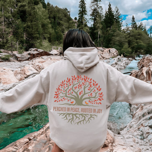 This design features a beautifully crafted tree with flowing roots, symbolizing strength and connection, paired with the uplifting saying, "Perched in peace, rooted in joy."