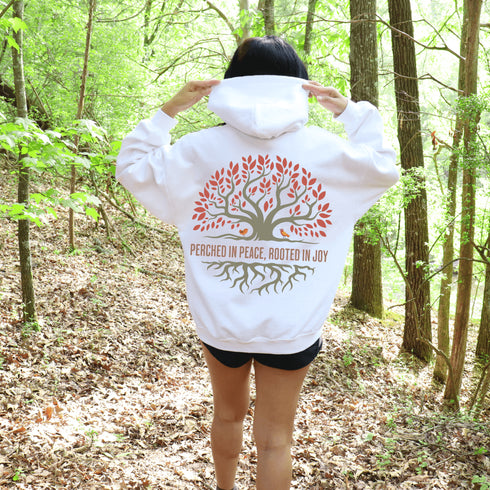 This design features a beautifully crafted tree with flowing roots, symbolizing strength and connection, paired with the uplifting saying, "Perched in peace, rooted in joy."