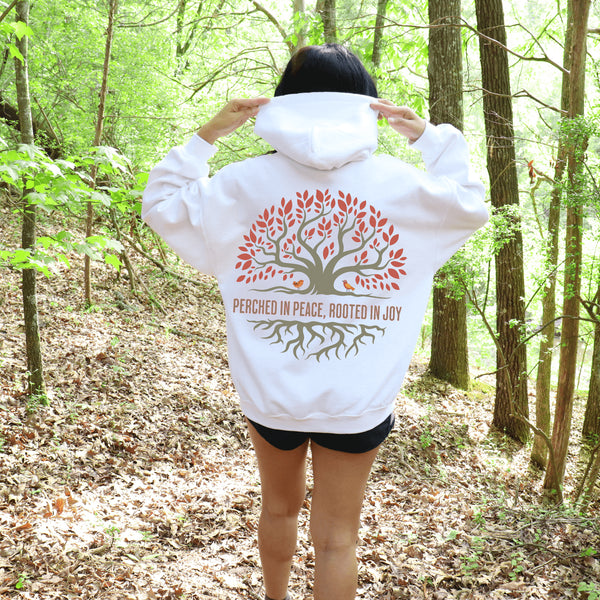 This design features a beautifully crafted tree with flowing roots, symbolizing strength and connection, paired with the uplifting saying, "Perched in peace, rooted in joy."