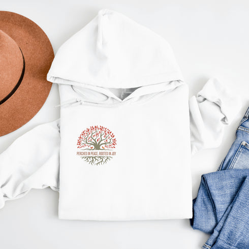 This design features a beautifully crafted tree with flowing roots, symbolizing strength and connection, paired with the uplifting saying, "Perched in peace, rooted in joy."