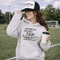 Soccer mom hoodie with “Running on Coffee and Game Day Chaos” design featuring moms cheering on the sidelines with kids playing soccer in the background