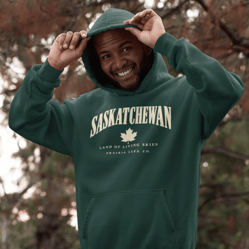 Saskatchewan Land of Living Skies unisex hoodie with vintage collegiate lettering and maple leaf graphic by Prairie Life Co.