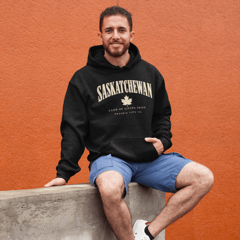 Saskatchewan Land of Living Skies unisex hoodie with vintage collegiate lettering and maple leaf graphic by Prairie Life Co.