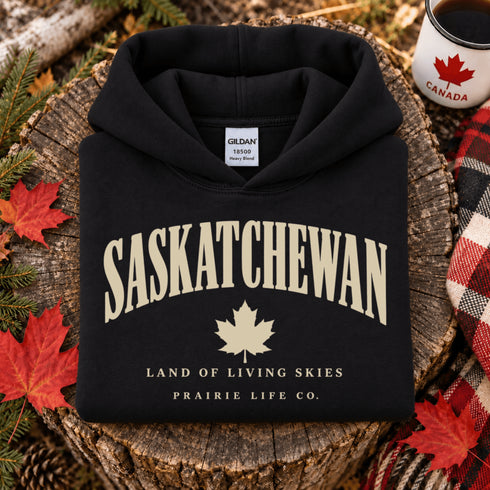 Saskatchewan Land of Living Skies unisex hoodie with vintage collegiate lettering and maple leaf graphic by Prairie Life Co.