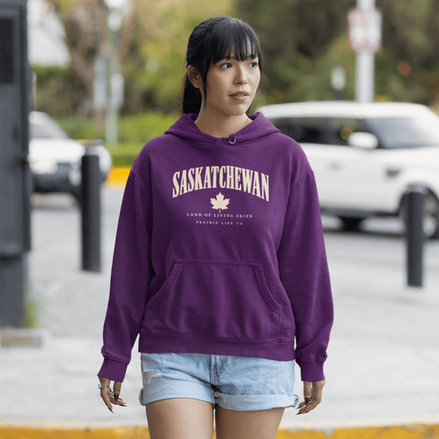 Saskatchewan Land of Living Skies unisex hoodie with vintage collegiate lettering and maple leaf graphic by Prairie Life Co.