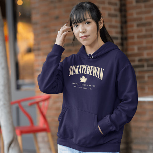 Saskatchewan Land of Living Skies unisex hoodie with vintage collegiate lettering and maple leaf graphic by Prairie Life Co.