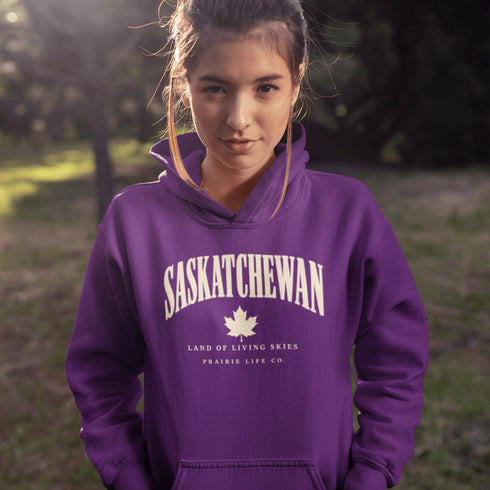 Saskatchewan Land of Living Skies unisex hoodie with vintage collegiate lettering and maple leaf graphic by Prairie Life Co.