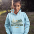 person wearing saskatchewan prairie life hoodie with farm and wheat field design standing in prairie field