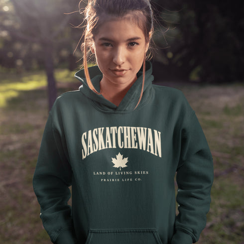 Saskatchewan Land of Living Skies unisex hoodie with vintage collegiate lettering and maple leaf graphic by Prairie Life Co.