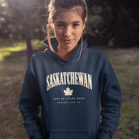 Saskatchewan Land of Living Skies unisex hoodie with vintage collegiate lettering and maple leaf graphic by Prairie Life Co.
