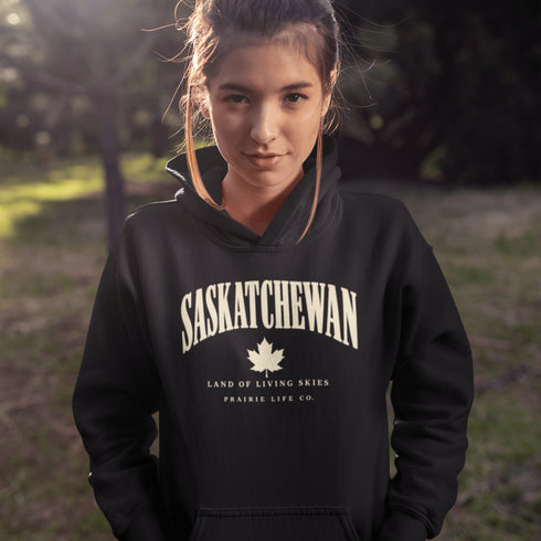 Saskatchewan Land of Living Skies unisex hoodie with vintage collegiate lettering and maple leaf graphic by Prairie Life Co.