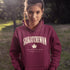 Saskatchewan Land of Living Skies unisex hoodie with vintage collegiate lettering and maple leaf graphic by Prairie Life Co.