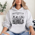 Soccer mom hoodie with “Sideline Social Club” design featuring moms sitting in lawn chairs drinking coffee while watching kids play soccer in the background