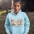 Small Town Big Hockey Dreams Hoodie – nostalgic pond hockey sweatshirt with campfire winter scene. Cozy unisex fit. Multiple colors available.
