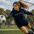 Person wearing “Soccer Nerd” hoodie holding a soccer ball on a soccer field during a game, casual athletic soccer apparel