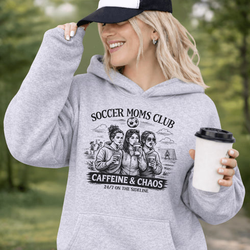 Soccer moms hoodie with “Soccer Moms Club Caffeine and Chaos” design featuring moms holding coffee cups and watching kids play soccer in the background