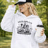 Soccer moms hoodie with “Soccer Moms Club Caffeine and Chaos” design featuring moms holding coffee cups and watching kids play soccer in the background