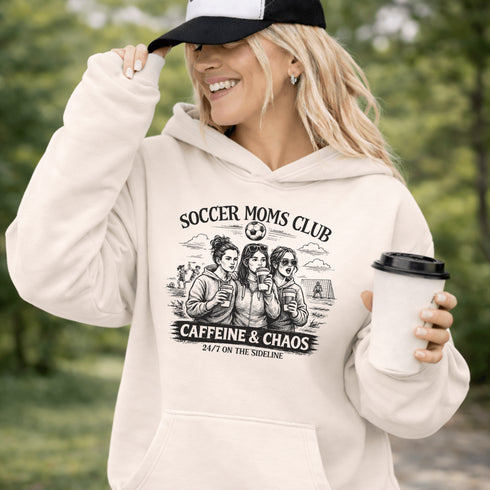 Soccer moms hoodie with “Soccer Moms Club Caffeine and Chaos” design featuring moms holding coffee cups and watching kids play soccer in the background