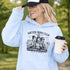 Soccer moms hoodie with “Soccer Moms Club Caffeine and Chaos” design featuring moms holding coffee cups and watching kids play soccer in the background