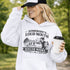 woman wearing grey hoodie with “Somebody’s Loud Mouth Soccer Mama” design featuring mom yelling on soccer sideline with kids playing in background