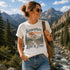 Woman wearing a t-shirt with a nature-themed design in a mountainous landscape