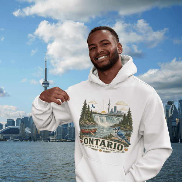 Man wearing a hoodie with Ontario-themed design in front of a city skyline and water body.