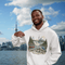 Man wearing a hoodie with Ontario-themed design in front of a city skyline and water body.