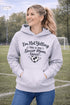 Woman wearing a hoodie that says “I’m Not Yelling This Is My Soccer Mom Voice” with a soccer ball heart design, standing on a soccer field