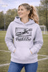 woman wearing hoodie with “When In Doubt Punch It Out” soccer goalie design featuring diving goalkeeper making a save in front of net