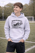Teenaged boy wearing grey hoodie with “When In Doubt Punch It Out” soccer goalie design featuring diving goalkeeper making a save