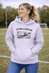 woman wearing grey hoodie with “Fear The Goalie” soccer goalkeeper design featuring diving goalie making a save