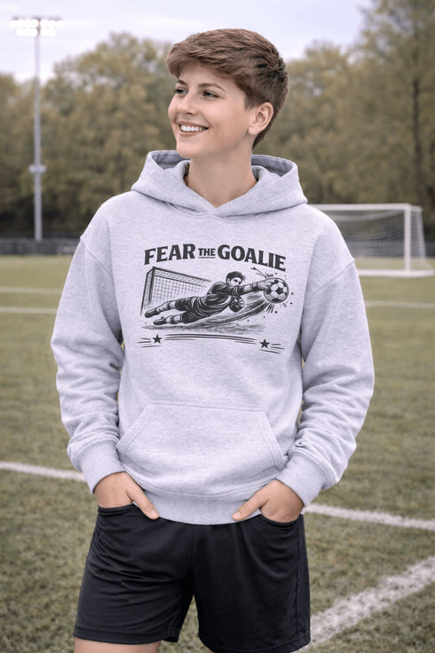 youth wearing grey hoodie with “Fear The Goalie” soccer goalkeeper design featuring diving goalie making a save