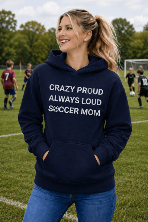 Woman wearing a navy hoodie with 'Crazy proud always loud soccer mom' text on a soccer field.