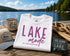 White t-shirt with 'Lake Mode' text on a dock by a lake
