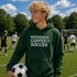 Person wearing a green hoodie with 'Weekends Coffee Soccer' text on a soccer field.