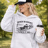 Woman wearing grey hoodie with “When In Doubt Punch It Out” soccer goalie design featuring diving goalkeeper making a save