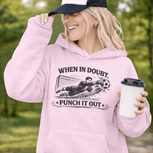 Woman wearing grey hoodie with “When In Doubt Punch It Out” soccer goalie design featuring diving goalkeeper making a save